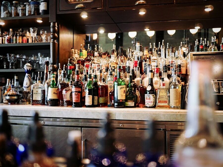 Shelves of drinks behind a traditional British pub bar